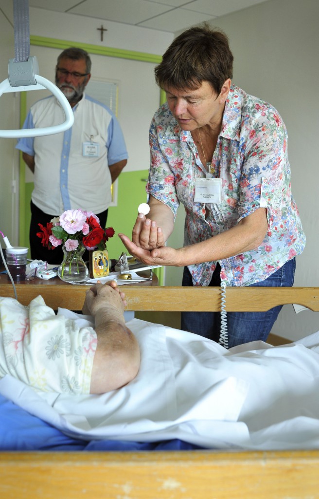 25 Juin 2013 : Olivia DUJARDIN est une laïque aumônier de l'Hôpital Saint Vincent de Paul ( Groupement des Hôpitaux de l'Institut Catholique de Lille). Formée au CIPAC (Centre interdiocésain de formation pastorale et catéchétique) elle a reçu une lettre de mission de l'évêque de Lille et elle est rémunérée par l'hôpital. Ici, elle vient porter la communion à une malade en fin de vie dans l'Unité de Soins Palliatifs de ce même hôpital. Lille (59) France. June 2013 : Volunteers accompany patients at end of life in the Palliative Care Center of the St Vincent de Paul hospital. Lille (59), France.