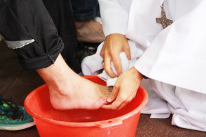 Un évêque lavant les pieds d'un homme, comme Jésus a lavé les pieds de ses apôtres.