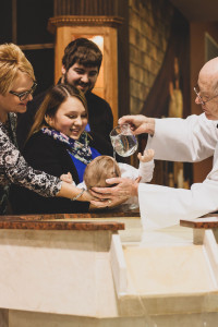Parents et marraine lors du baptême d'un enfant.
